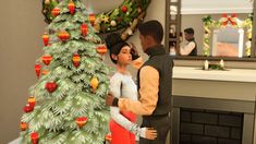 a man and woman standing next to a christmas tree