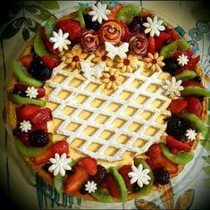 a cake with fruit and flowers on it