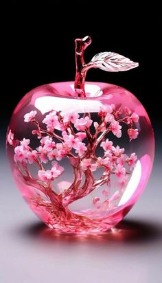 an apple shaped sculpture with pink flowers in it