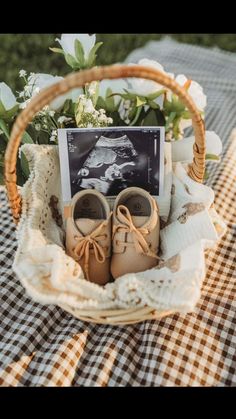 a basket filled with baby's shoes on top of a checkered table cloth