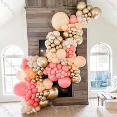 the balloon arch is decorated with gold, pink and white balloons in front of a fireplace