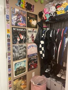 a closet with posters and other items hanging on the wall next to a trash can