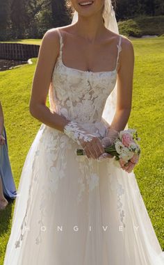 a woman in a wedding dress standing on the grass