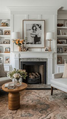 a living room filled with furniture and a fire place in front of a white fireplace