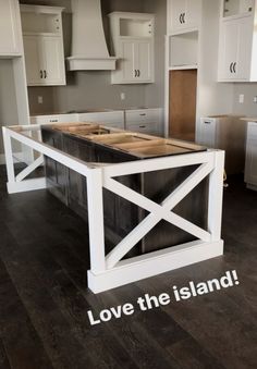 a kitchen with white cabinets and an island that has the words love the island on it