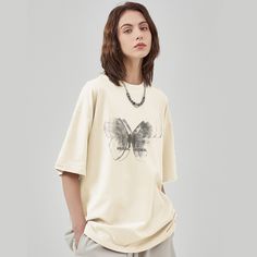 This Japanese simple butterfly T-shirt adds an elegant touch to any outfit. Its crisp white hue and classic design are perfect for any occasion, making it a timeless addition to any wardrobe. The delicate butterfly understatedly alludes to the beauty of nature and makes for a subtly sophisticated statement. Features: -100% Cotton -Crew Neckline -Dropped Shoulder -Butterfly -Letter -Regular fit -Japanese style White Minimalist T-shirt For Spring, White Minimalist T-shirt For Summer, White Butterfly-shaped Top For Summer, Trendy White T-shirt With Butterfly Print, White Butterfly T-shirt For Summer, White Butterfly T-shirt For Spring, Trendy Short Sleeve T-shirt With Butterfly Print, Trendy Cotton T-shirt With Butterfly Print, Casual T-shirt With Butterfly Print