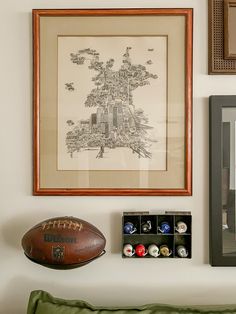 a football is on the wall next to a framed map and other items that are below it