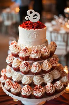 a three tiered wedding cake with cupcakes on the bottom and red velvet