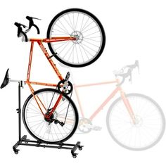 an orange bike is on top of a black stand