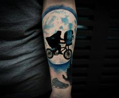 a man's arm with a tattoo on it that has an image of a person riding a bike in front of the moon