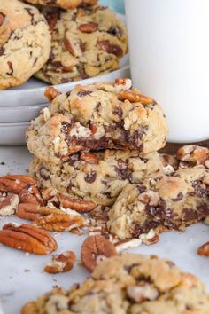 chocolate chip cookies with pecans and nuts next to a glass of milk