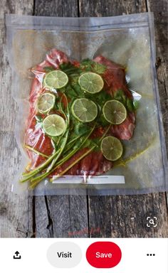 a plastic bag filled with meat and veggies on top of a wooden table