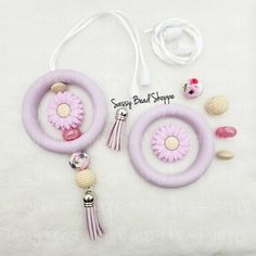 the pink and white necklace has flowers on it, along with other accessories such as beads