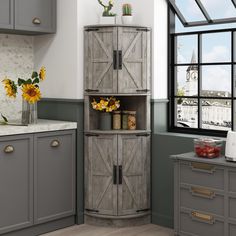 a kitchen with gray cabinets and sunflowers in vases on the window sill