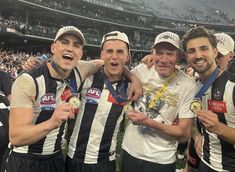 three men standing next to each other holding up their medals and posing for a photo