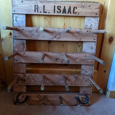 an old wooden crate sitting on the floor next to a wall with writing that reads r l isaac