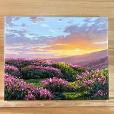 a painting of pink flowers on a wooden shelf