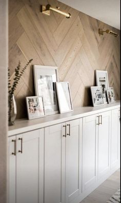 a room with white cabinets and pictures on the wall