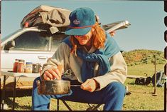 a woman sitting on a chair with a pot in front of her