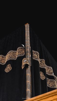 an elaborately designed black and gold cloth covering a tall pole with intricate designs on it