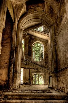 black and white photograph of an old building with stairs leading up to the window in the middle