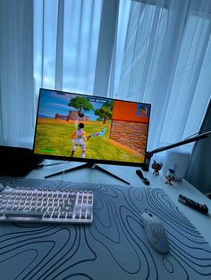 a computer monitor sitting on top of a desk next to a keyboard and mouse in front of a window