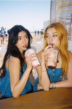 two women sitting at a table drinking beverages