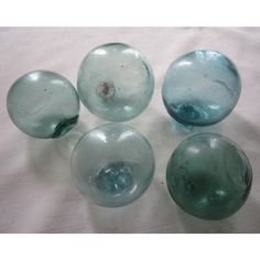 four glass vases sitting on top of a white cloth