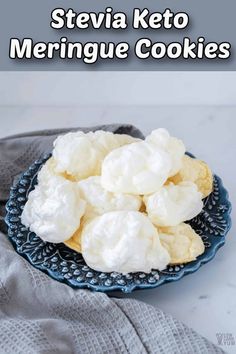 a blue plate topped with meringue cookies on top of a white tablecloth