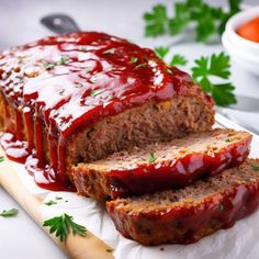 sliced meatloaf with ketchup and parsley on cutting board