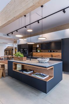 an open concept kitchen and dining area with wooden ceiling beams, black cabinets and counter tops