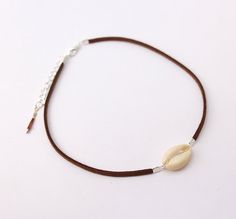 This choker necklace is made whith genuine brown leather lace adorned with a white cowrie shell.------ ▲ ▲ ▲ ------SIZE:> Chain length: 31 cm (36 cm with the little chain)Closing-system : AdjustableMATERIAL:> genuine leather> Silver plated metal> Cowrie shellNickel free jewelry !COLOR:> Brown> White> Silver------ ▲ ▲ ▲ ------Comes in its own handmade gift package, ready to be given as a present. (If you want to).------ ▲ ▲ ▲ ------Follow me:> Facebookhttp://facebook.com/sarayana.fr> Official sit Brown Necklace For Summer Festivals, Handmade Brown Choker For Beach, Festival Shell Choker Necklace, Bohemian Brown Cowrie Shell Jewelry, Beach Brown Choker Necklace, Brown Choker Necklace For The Beach, Brown Choker Necklace For Beach, Lace Choker Necklace, Festival Necklace