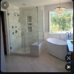 a large white bath tub sitting next to a walk in shower