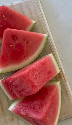 four slices of watermelon on a cutting board