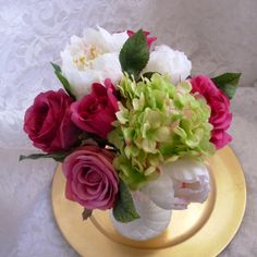 a vase filled with flowers on top of a gold plate