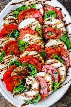 grilled tomatoes and mozzarella with balsami dressing on a white platter