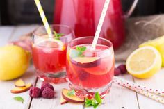 two glasses filled with drinks sitting on top of a red and white checkered table cloth