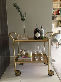 a gold bar cart with drinks on it