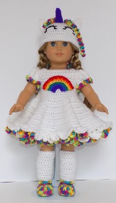 a crocheted doll wearing a white dress and rainbow socks