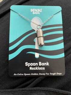 the spoon bank necklace is attached to a card