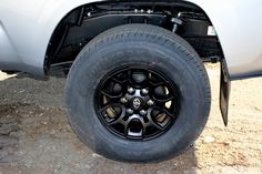 the front wheel of a white truck with black spokes