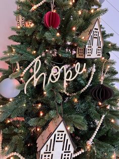 a christmas tree decorated with paper houses and ornaments