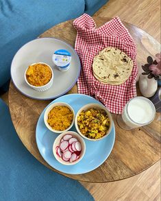 two bowls of food on a table next to a plate with an egg and bread