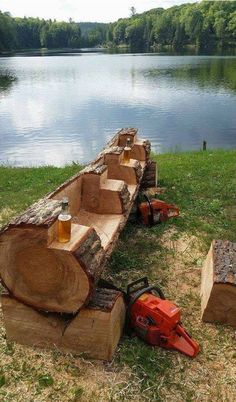 a chainsaw is sitting on the grass next to some logs and beer mugs