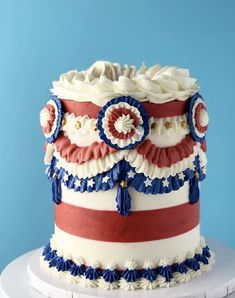 a red, white and blue cake sitting on top of a table next to a blue wall