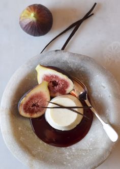 a white plate topped with sliced figs and sauce