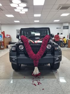 a car decorated with flowers and ribbons in the shape of v on display at a showroom