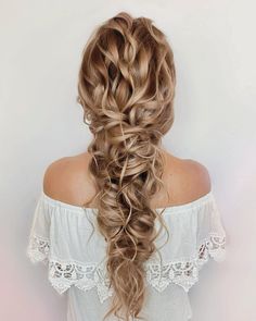 a woman with long, curly hair in a half - up braid is shown from the back