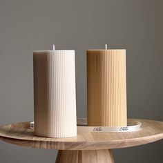 two candles sitting on top of a wooden table