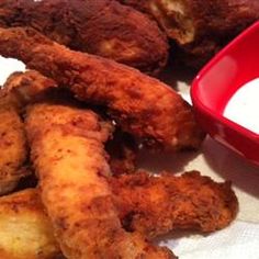 some fried food is next to a bowl of yogurt